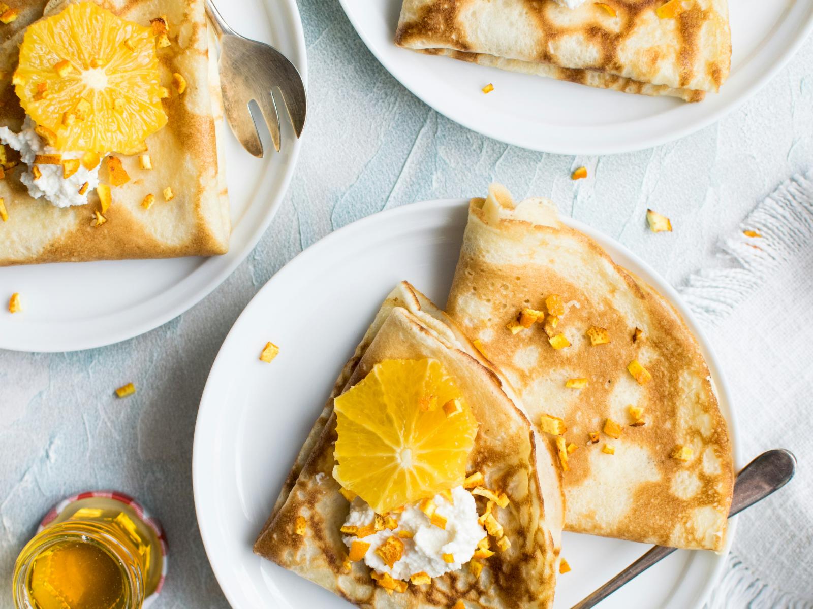 pancakes on plate with honey and orange
