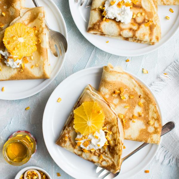 pancakes on plate with honey and orange